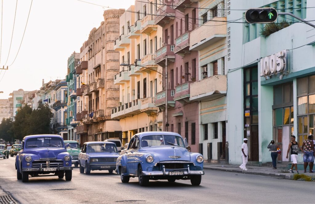 Classic American cars driving through the streets of Havana, Cuba.